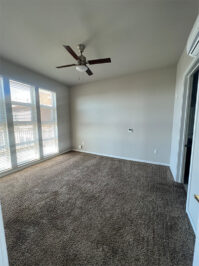 Apartment bedroom with carpet and large windows