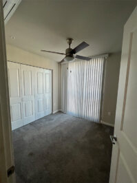 Apartment bedroom with carpet and large windows